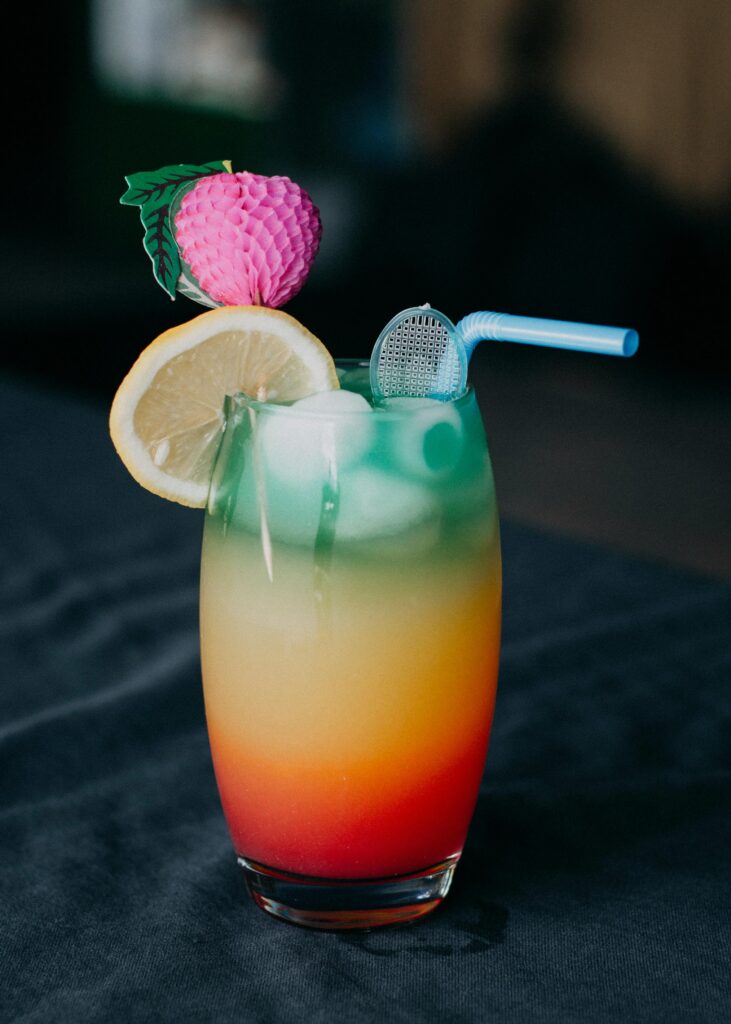 Vibrant cocktail with ice and fruit garnish, perfect for a tropical experience.